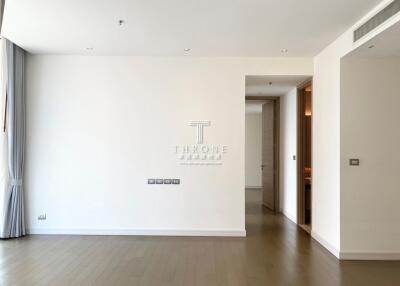 Spacious and well-lit empty living room with hardwood floors and neutral color scheme