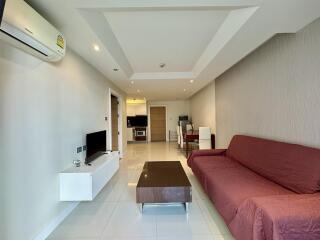 Spacious living room with modern furniture and open plan layout leading to the kitchen