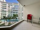 Spacious balcony with a view of the pool and surrounding apartment buildings