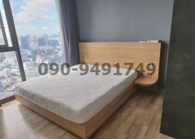 Spacious bedroom with a large window and city view