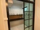 Modern entryway with glass door and built-in cabinets