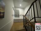 Modern staircase landing with wooden floors, picture on wall, and natural light