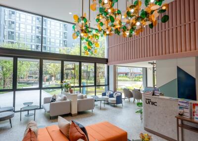 Modern lobby interior with colorful art installation, comfortable seating, and high ceiling