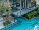 Modern two-story building with glass walls, an outdoor swimming pool, and a green rooftop