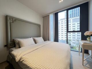 Modern furnished bedroom with a large bed and city view