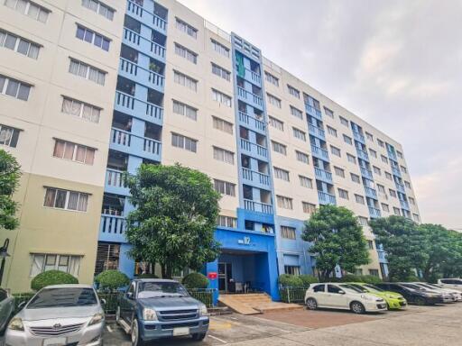 Exterior view of a modern apartment building with parking space