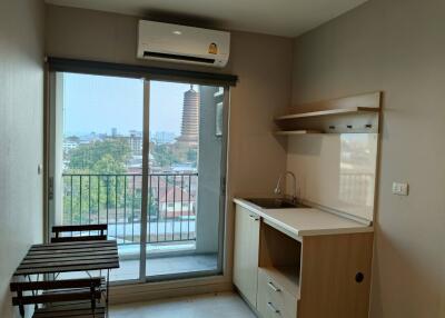 Compact kitchen with city view and balcony access featuring modern amenities and ample natural light
