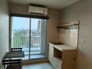 Compact kitchen with city view and balcony access featuring modern amenities and ample natural light