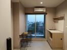 Compact apartment interior with kitchenette, dining area and city view