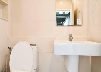 Modern bathroom interior with wall-mounted sink, toilet and mirror