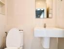 Modern bathroom interior with wall-mounted sink, toilet and mirror