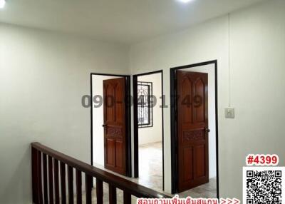 Interior view of a well-lit hallway with wooden doors and tiled floor