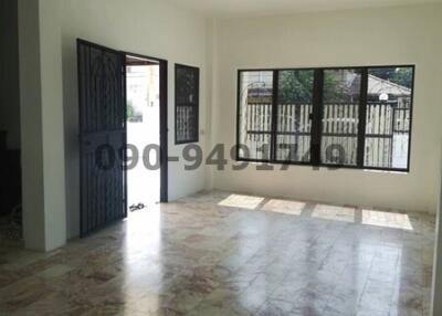Spacious and empty living room with large windows and tiled flooring