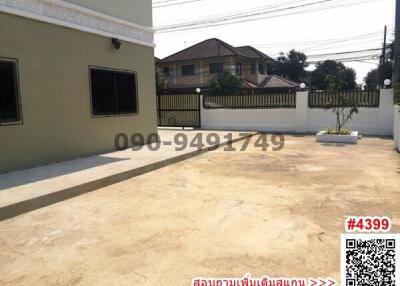 Spacious paved outdoor area with driveway and fencing around the property