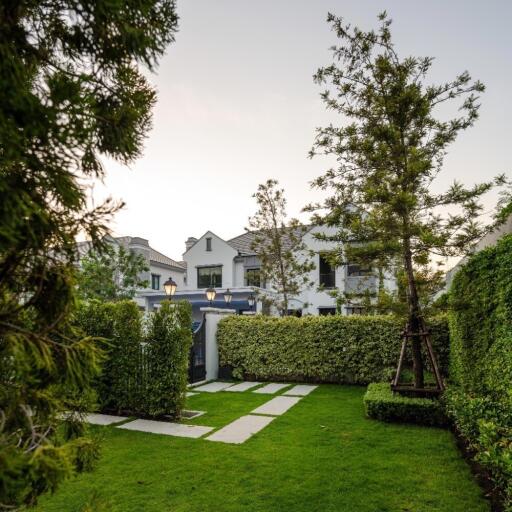 Lush garden and exterior of a luxurious home at dusk