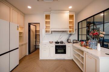 Modern kitchen with wooden floor and white cabinets