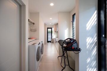 Compact laundry room with modern appliances and ample storage space