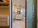 Modern bathroom with glass door, marble walls, and vanity area