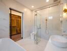 Modern bathroom with white marble tiles, walk-in shower, and gold fixtures