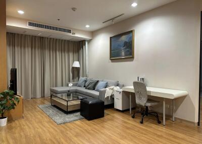 Modern living room with wood flooring, ample seating, and workstation