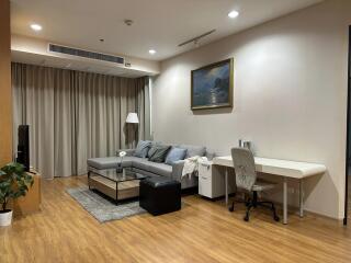 Modern living room with wood flooring, ample seating, and workstation