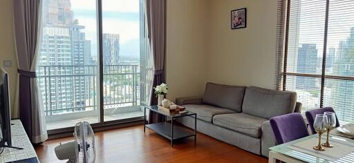 Spacious and well-lit living room with modern furniture and city view