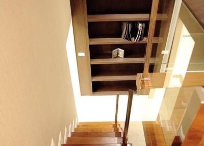 Modern wooden staircase with glass balustrade leading to a lower level