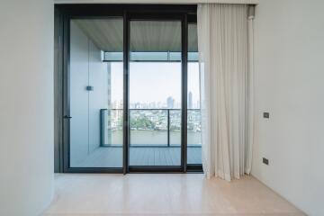 Modern apartment with floor-to-ceiling sliding glass doors leading to balcony and city view