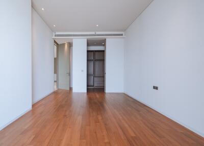 Spacious empty room with hardwood flooring and white walls