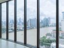 Spacious living room with floor-to-ceiling windows offering a panoramic city and river view