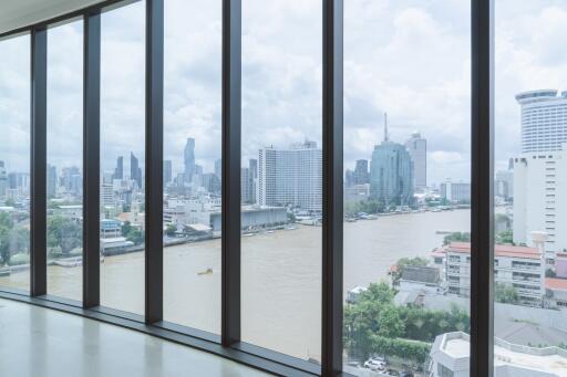 Spacious living room with floor-to-ceiling windows offering a panoramic city and river view