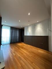 Spacious living room with hardwood floors and modern lighting