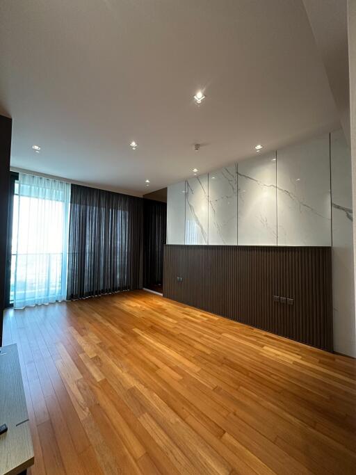 Spacious living room with hardwood floors and modern lighting