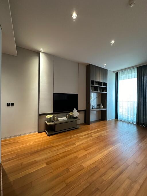 Modern living room with wooden flooring, large window and built-in shelving