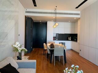 Modern open plan kitchen with dining table in a well-lit apartment