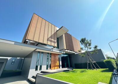 Modern two-story house with an expansive lawn and impressive architectural design