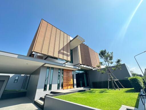 Modern two-story house with an expansive lawn and impressive architectural design