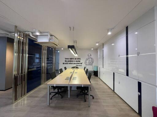 Modern office interior with a long conference table, comfortable chairs, and artistic wall decorations