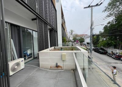 Modern building exterior with balcony and glass facade overlooking the street