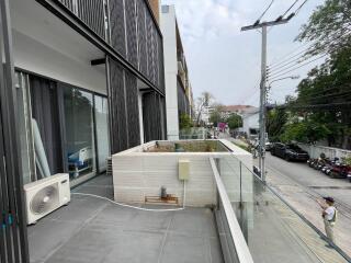 Modern building exterior with balcony and glass facade overlooking the street