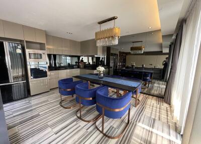 Modern kitchen with dining area, stainless steel appliances, and a large dining table