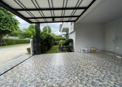 Tiled patio space with a roof and garden view
