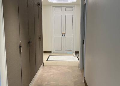 Clean and well-lit entryway with herringbone flooring and built-in storage