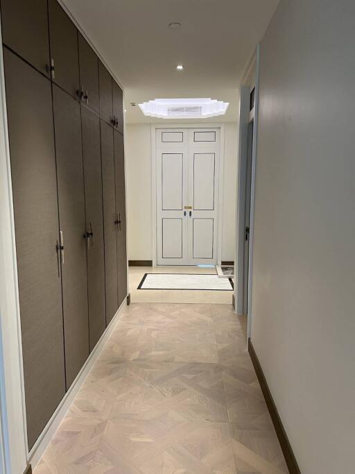 Clean and well-lit entryway with herringbone flooring and built-in storage