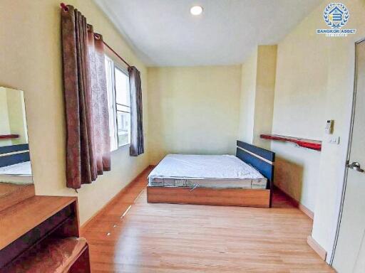 Cozy bedroom with a double bed, wooden flooring, and ample natural light