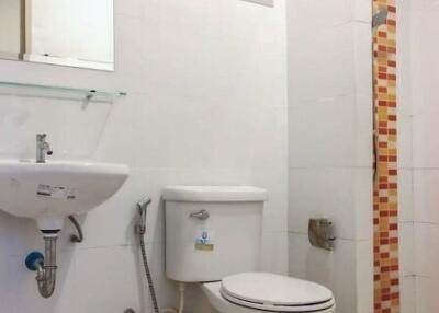Modern bathroom with tiled walls and white sanitary fixtures