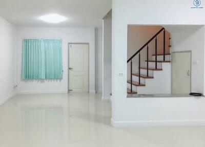 Spacious white living room with stairs and glossy tiled floor
