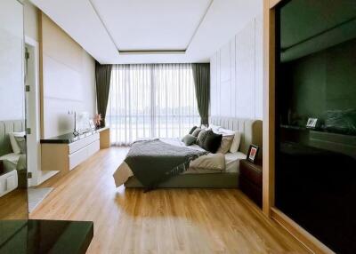 Spacious modern bedroom with large windows and hardwood floors