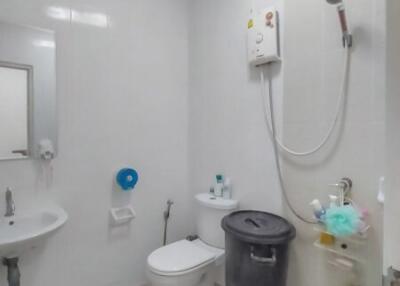 White modern bathroom with toilet, shower, and sink
