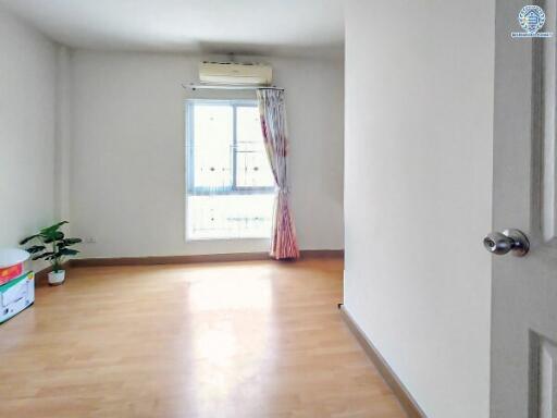 Bright and empty bedroom with wooden flooring and a window